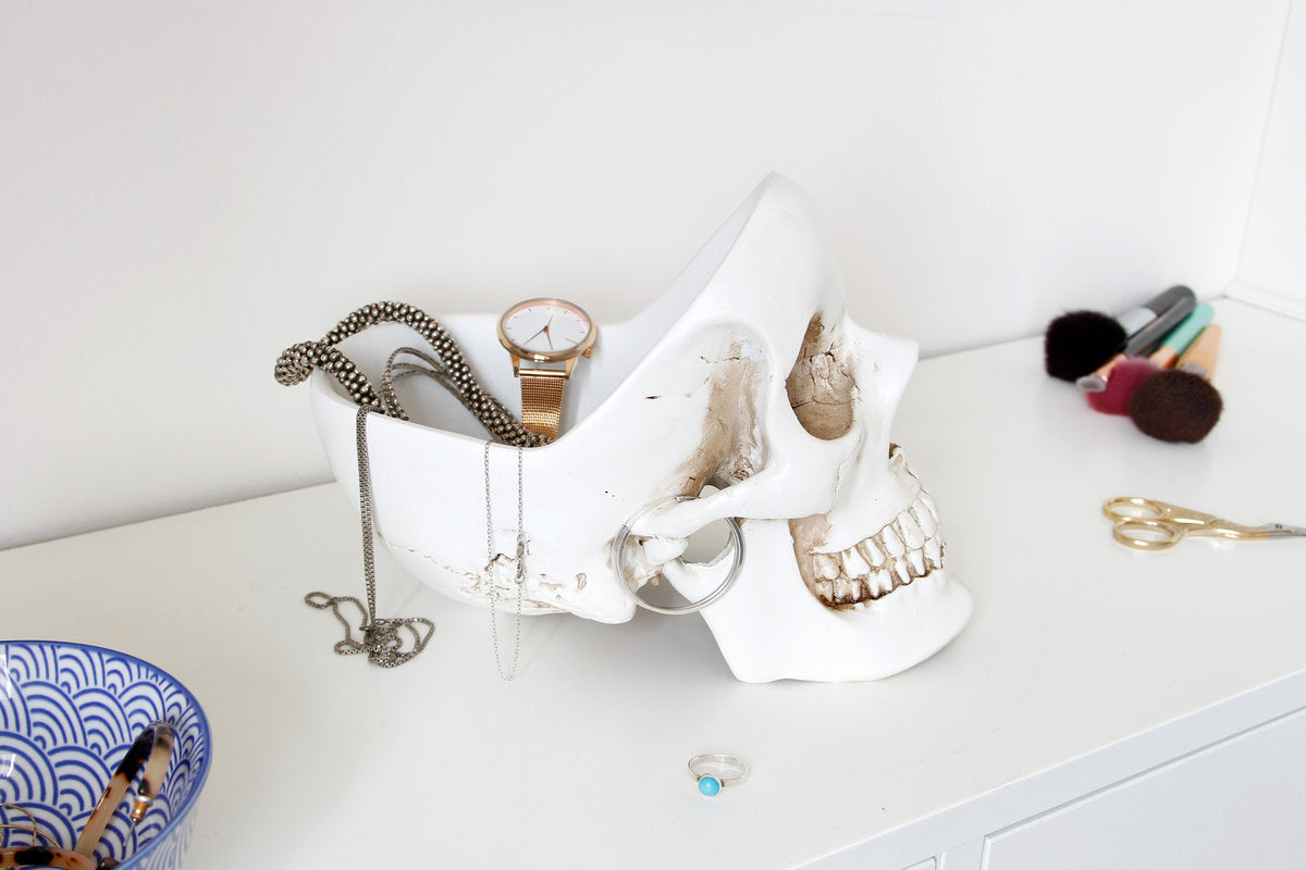 White Skull Tidy storing a watch, necklaces and jewellery on a desk