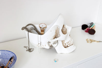 White Skull Tidy storing a watch, necklaces and jewellery on a desk